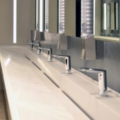 commercial bathroom, sink and containers for antibacterial soap antiseptic in a public toilet. Coronavirus and hand washing concept.